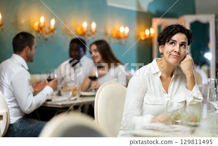 Sad woman with glass at the restaurant 129811495