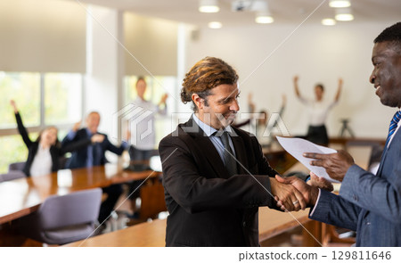 Businessmen handshaking after having agreement Businessmen handshaking after having agreement 129811646