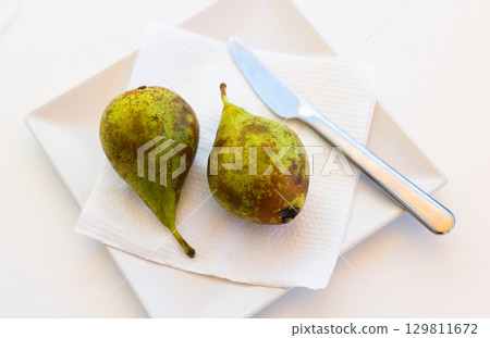 Juicy pear fruits served to table 129811672