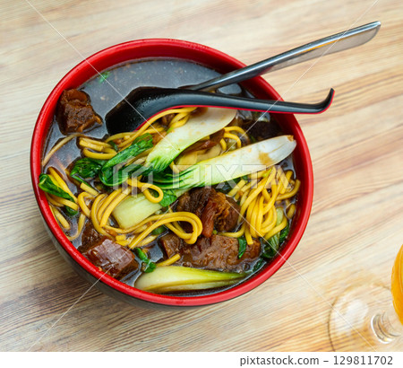 Ramen soup with wheat noodles, beef and swiss chard 129811702