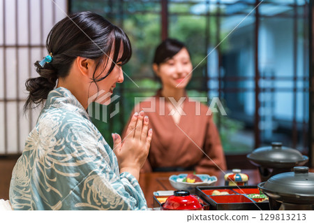 A woman in a yukata eating dinner at a hot spring inn, in-room dining, or in a traditional Japanese inn 129813213