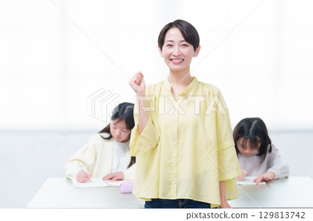 A girl studying and her mother giving a thumbs up A girl studying and her mother giving a thumbs up 129813742