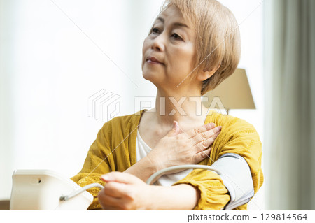 一位老年婦女在客廳測量血壓 129814564