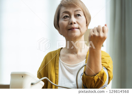一位老年婦女在客廳測量血壓 129814568