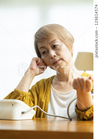 一位老年婦女在客廳測量血壓 129814574