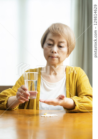 Senior woman taking a large amount of medicine Senior woman taking a large amount of medicine 129814629