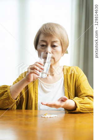 Senior woman taking a large amount of medicine Senior woman taking a large amount of medicine 129814630