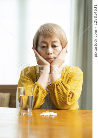 Senior woman taking a large amount of medicine 129814631