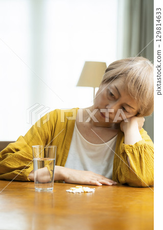 Senior woman taking a large amount of medicine 129814633