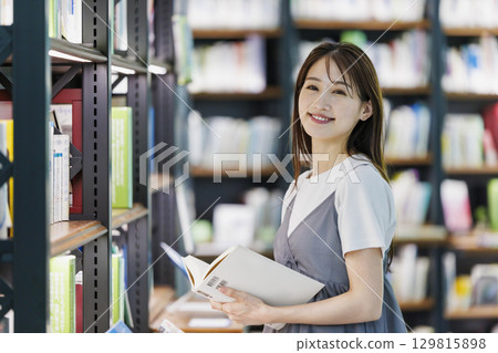 尋找一本書在圖書館裡的年輕女子 129815898