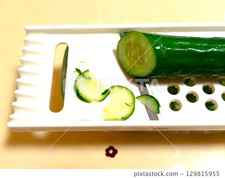 Slice the cucumber into rounds using a slicer 129815955