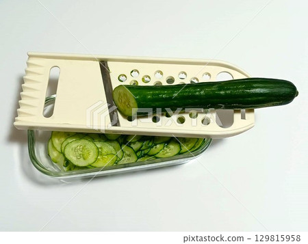 Slice the cucumber into rounds using a slicer 129815958