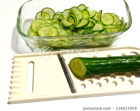 Slice the cucumber into rounds using a slicer Slice the cucumber into rounds using a slicer 129815959