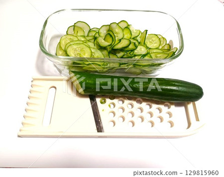Slice the cucumber into rounds using a slicer Slice the cucumber into rounds using a slicer 129815960