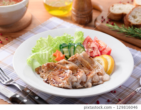 A classic Western dish of sauteed pork and a colorful vegetable platter. A perfect dish for home cooking or restaurant meals. 129816046