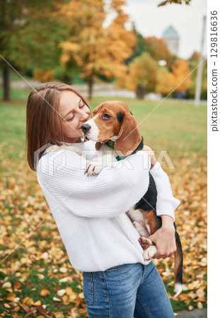 Young woman is with her dog in the park Young woman is with her dog in the park 129816636
