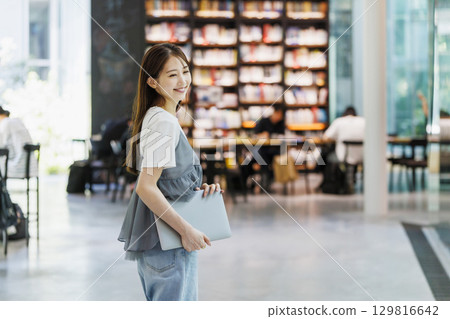 站在圖書館裡的年輕女子 站在圖書館裡的年輕女子 129816642