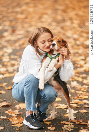 Young woman is with her dog in the park 129816731