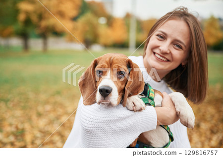 Young woman is with her dog in the park 129816757