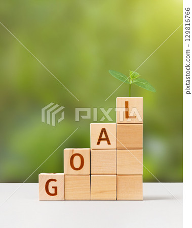 Wooden cubes with word goal and young green seedling are a symbol of success. Development to success, planning and motivation in 2026, challenge and business strategy in new year, business progress Wooden cubes with word goal and young green seedling are a symbol of success. Development to success, planning and motivation in 2026, challenge and business strategy in new year, business progress 129816766