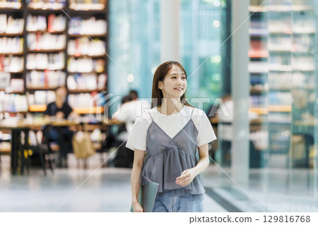 站在圖書館裡的年輕女子 129816768