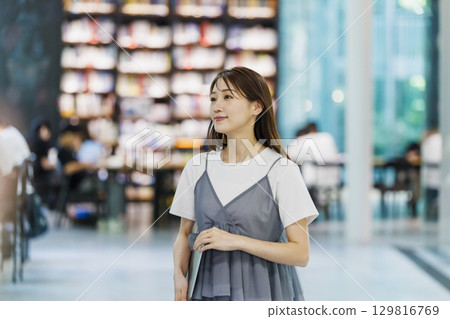 Young woman standing in the library 129816769
