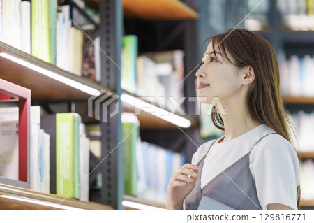 尋找一本書在圖書館裡的年輕女子 129816771