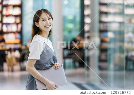 站在圖書館裡的年輕女子 129816773