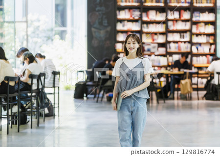 Young woman standing in the library 129816774