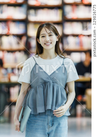 站在圖書館裡的年輕女子 129816775