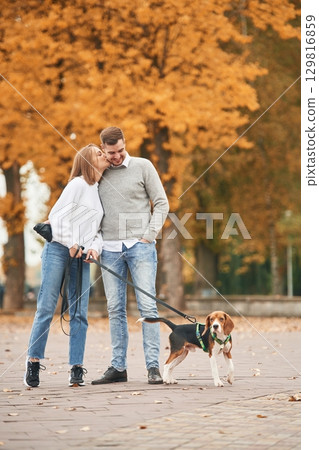 Lovely couple are with their cute dog outdoors Lovely couple are with their cute dog outdoors 129816859