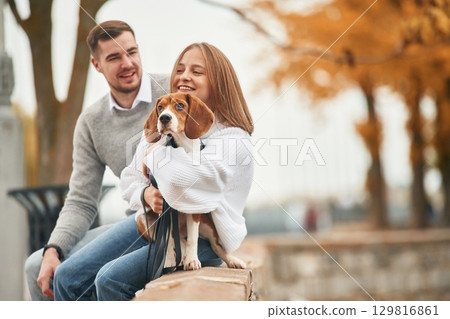 Lovely couple are with their cute dog outdoors 129816861