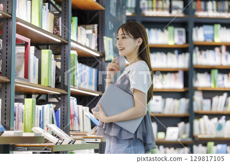 尋找一本書在圖書館裡的年輕女子 尋找一本書在圖書館裡的年輕女子 129817105