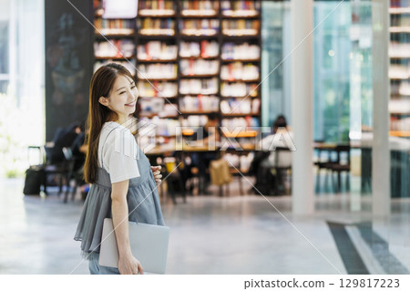站在圖書館裡的年輕女子 129817223