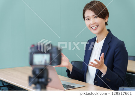 一名身穿西裝的女子用相機拍攝視頻 129817661