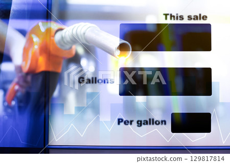 Gas station fuel pump nozzle with digital sale display showing gallons and price per gallon 129817814