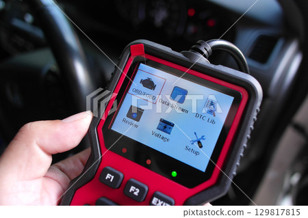 OBD2 scanner in hand, car diagnostic tool and code reader to check engine light, read and clear DTCs 129817815