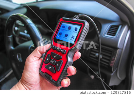 OBD2 scanner in hand, car diagnostic tool and code reader to check engine light, read and clear DTCs 129817816
