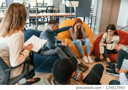 Woman needs help. Group of people are having therapy meeting together 129817993