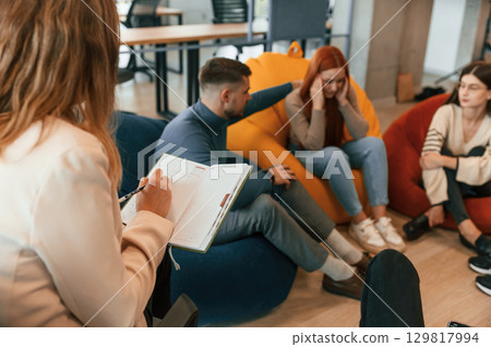Woman needs help. Group of people are having therapy meeting together 129817994