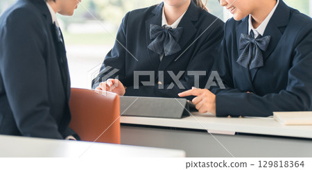 Elementary school, junior high school, high school, and female high school students (friends) talking to the student in front of them during class at school 129818364