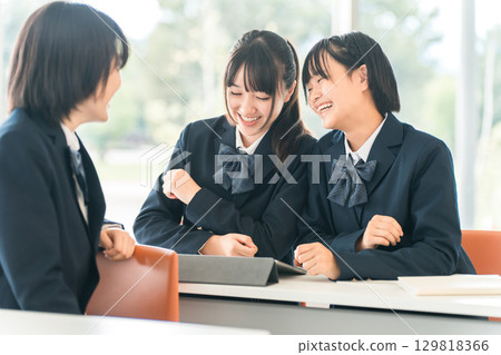 Elementary school, junior high school, high school, and female high school students (friends) talking to the student in front of them during class at school Elementary school, junior high school, high school, and female high school students (friends) talking to the student in front of them during class at school 129818366