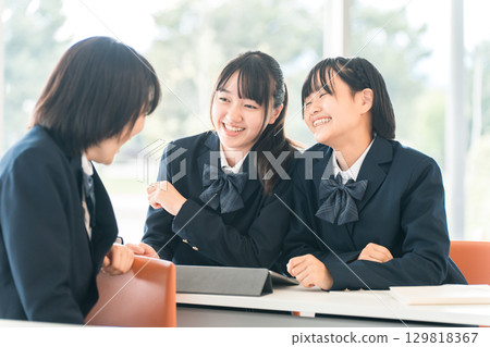Elementary school, junior high school, high school, and female high school students (friends) talking to the student in front of them during class at school Elementary school, junior high school, high school, and female high school students (friends) talking to the student in front of them during class at school 129818367
