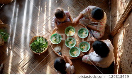 Asian family sharing traditional meal in bamboo house interior. Asian family sharing traditional meal in bamboo house interior. 129818429