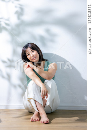 Summer sunlight: A woman leaning against a wall Summer sunlight: A woman leaning against a wall 129818851