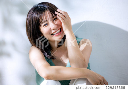 Summer sunlight: A woman leaning against a wall Summer sunlight: A woman leaning against a wall 129818866