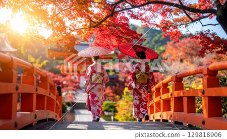 Geisha walking through a Kyoto-style landscape of autumn leaves 129818906