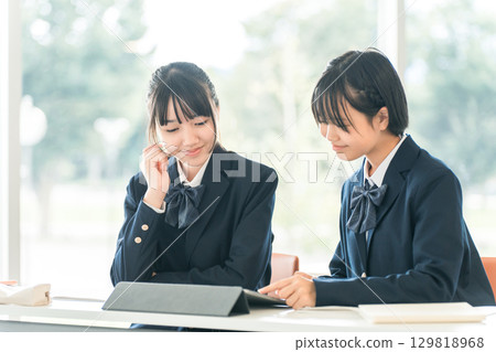 Elementary school, junior high school, and high school girls in uniforms taking classes in the classroom 129818968