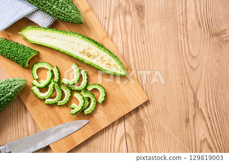 Bitter melon cut on a cutting board | Image of preparation and cooking process Bitter melon cut on a cutting board | Image of preparation and cooking process 129819003