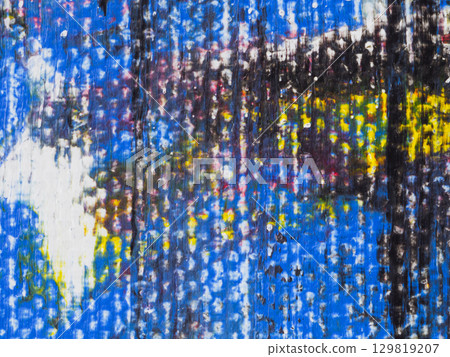 Colorful abstract artwork displayed on a textured surface in an artistic studio during daylight 129819207